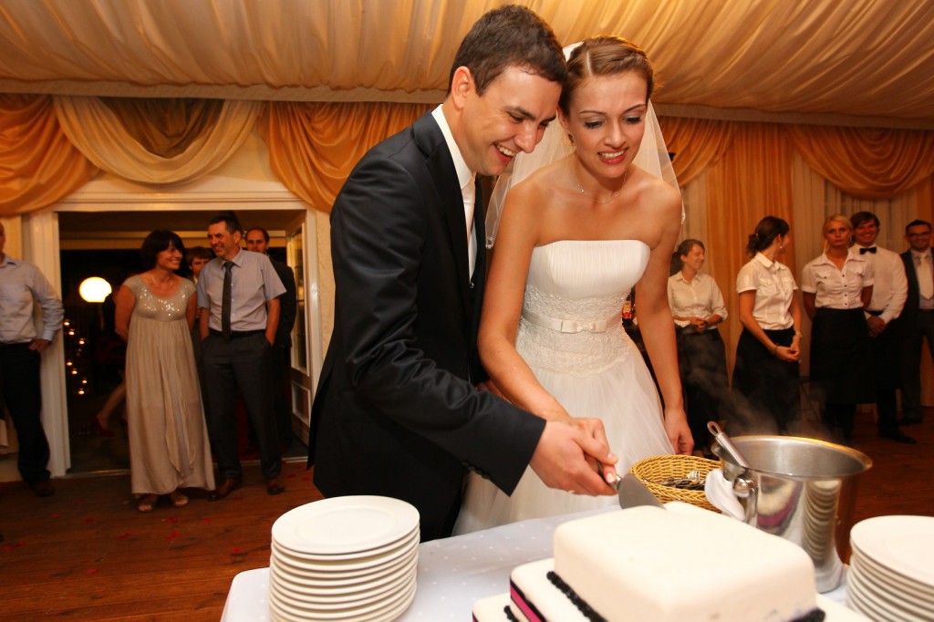 Para Młoda kroi tort weselny